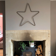 Load image into Gallery viewer, The rustic wall hung star above a fireplace.