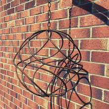 Load image into Gallery viewer, The rustic garden sphere and chain close up with a brick background.