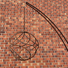 Load image into Gallery viewer, Rustic garden arch sculpture with chain and rustic garden sphere. Set against a brick background