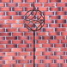 Load image into Gallery viewer, Decorative garden stake with a sphere on top with a brick background.