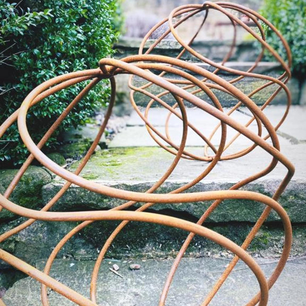 A large 40cm rustic garden ball infront of a smaller 34cm rustic garden ball outside on the garden steps. 