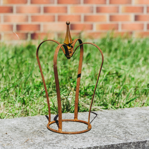 The small rustic garden crown with a wall and grass in the background. 