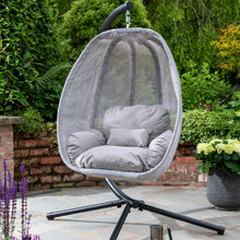 Load image into Gallery viewer, The folding textilene grey swing outside in the garden. 
