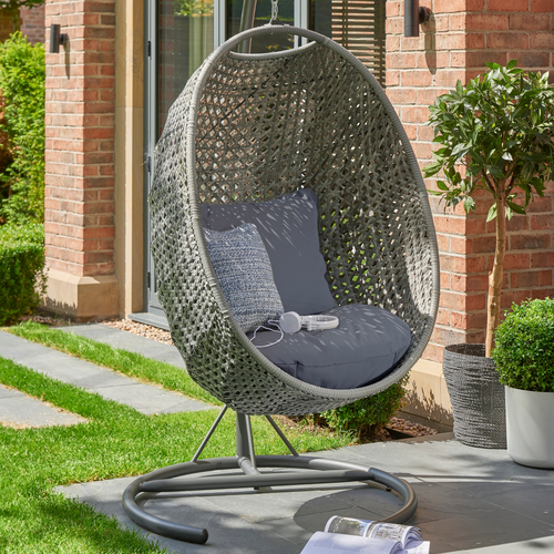 The Goldcoast single swing chair in grey in the garden. 