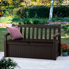 Load image into Gallery viewer, The Keter Iceni Storage Bench 265L Brown outside in the garden with a pillow. 
