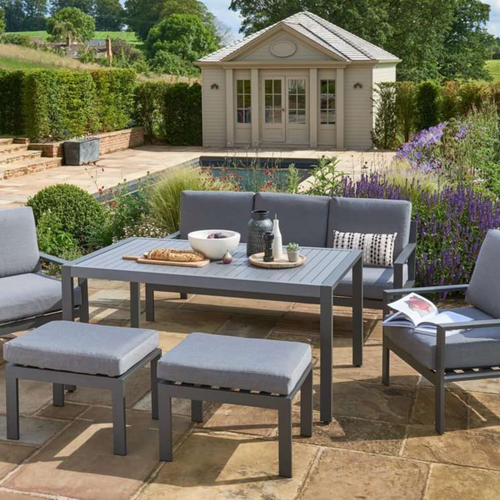 The Titchwell Lounge Set, in the garden with a summerhouse in the background. 