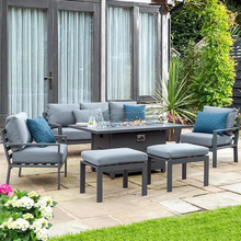 Load image into Gallery viewer, The Titchwell lounge set with firepit table on a garden patio. 
