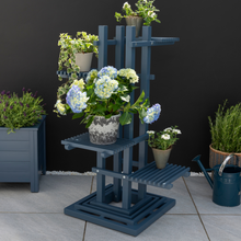 Load image into Gallery viewer, The Florenity Galaxy plant stand outside in the garden with a plant pot on each shelf. 
