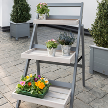 Load image into Gallery viewer, The Florenity Grigio Folding Pot Shelf outside in the garden.
