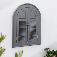 Load image into Gallery viewer, The Florenity Grigio outdoor arch mirror on a white wall with closed doors. 
