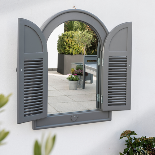 The Florenity Grigio Outdoor Arch Mirror on a white washed wall. 