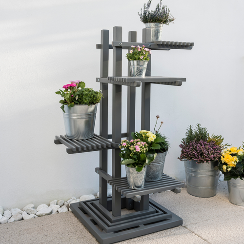 The Florenity Grigio Plant Stand with 5 plants on the various levels. The plant stand is outside on a garden patio. 