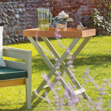 Load image into Gallery viewer, The Florenity Verdi Folding Butler Tray outside in the garden. 
