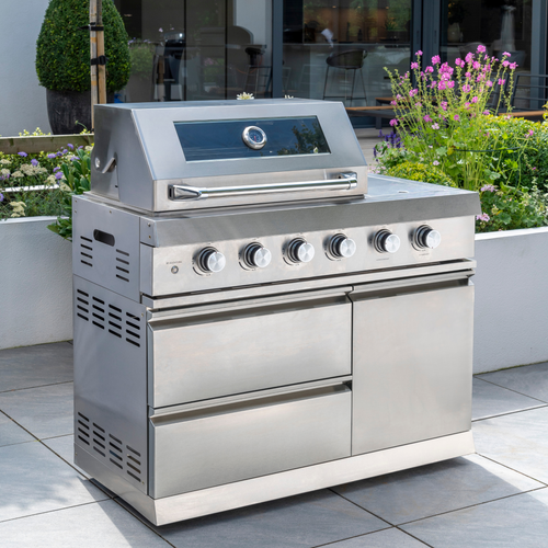 The Norfolk Grills Absolute 4 Burner Free Standing Grill with Side Burner and Cabinet stood in the garden. 