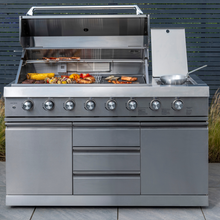 Load image into Gallery viewer, The Norfolk Grills absolute 6 burner free standing grill with side burner and cabinet outside in the garden with food grilling in.

