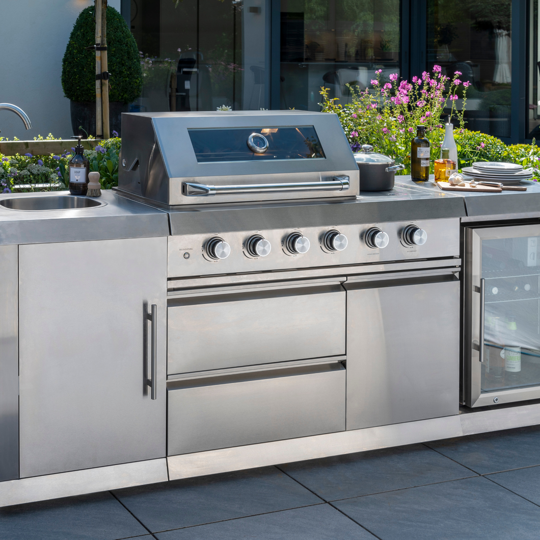 The Norfolk Grills Absolute Pro 4 Outdoor Kitchen Inc Fridge & Sink outside with plates and condiments on the outside kitchen. 