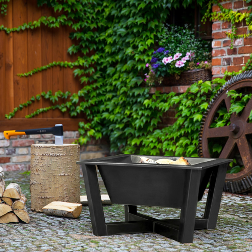 Cook King Brasil fire pit in the garden with wood and axe shown next to it. 