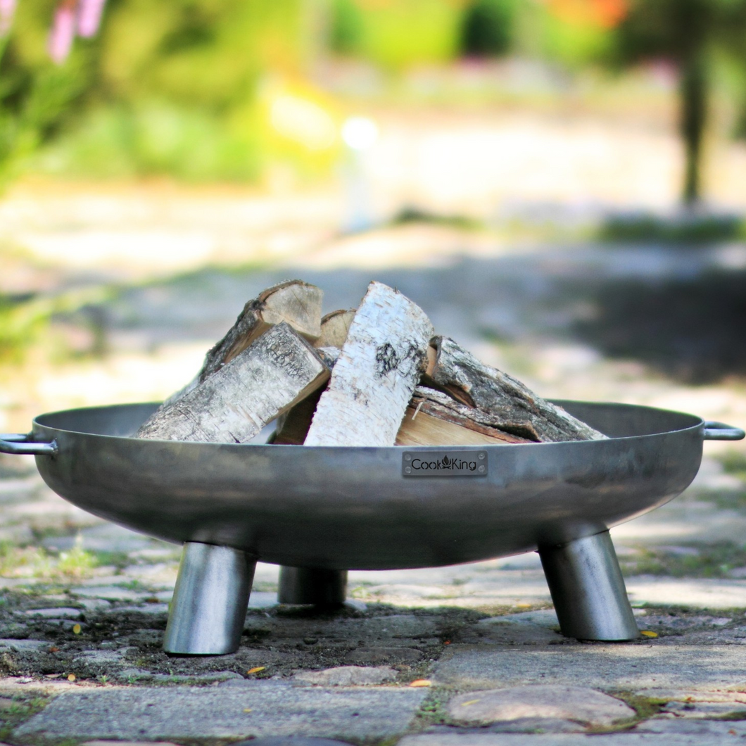 Cook King Bali fire pit outdoors with wood inside. 