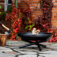 Load image into Gallery viewer, The Cook King Indiana Fire Bowl sat outdoors with wood inside. 
