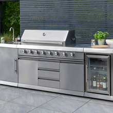 Load image into Gallery viewer, The Norfolk Grills Absolute Pro 6 Outdoor Kitchen Inc Fridge &amp; Sink outside with a grey wall behind. 
