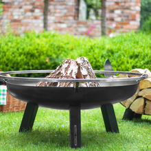 Load image into Gallery viewer, The Porto fire pit with wood inside in the garden. 
