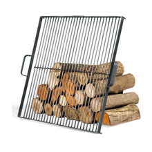 Load image into Gallery viewer, Cook King square grill leant against wooden logs on a white background. 
