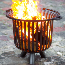 Load image into Gallery viewer, The Cook King Verona 60cm Fire Basket with fire lit and logs burning.
